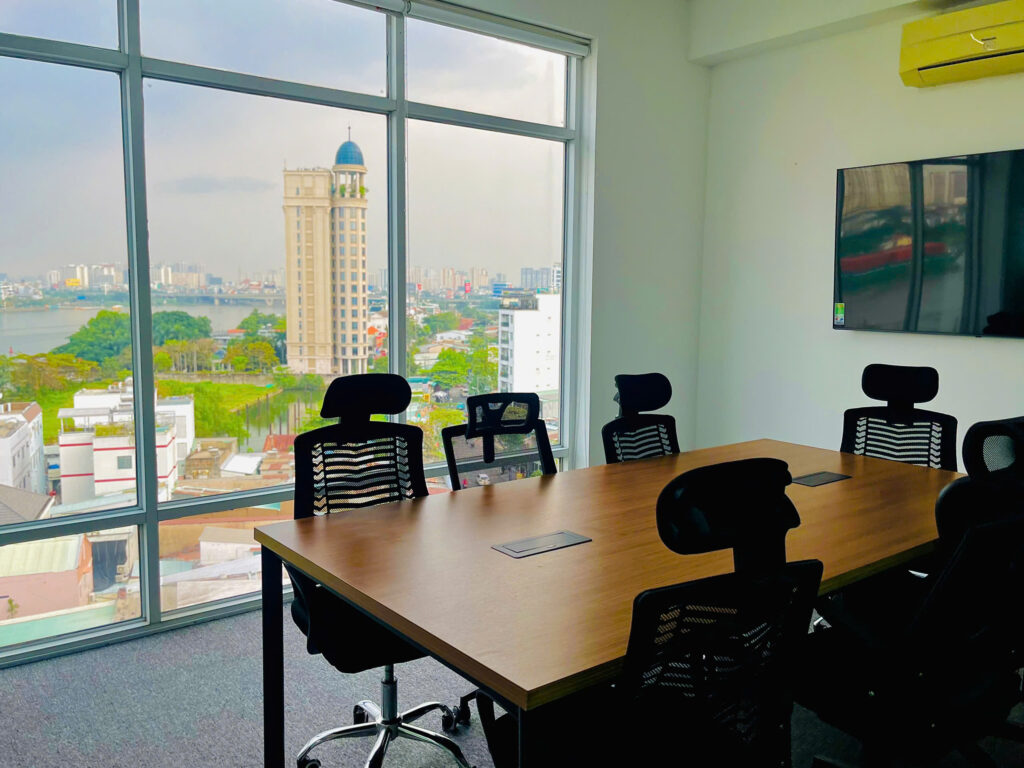A modern CLAH conference room featuring a large wooden table, ergonomic office chairs, and floor-to-ceiling windows with a city view, illustrating the strategic expansion of Admin and Logistics operations to support global growth.